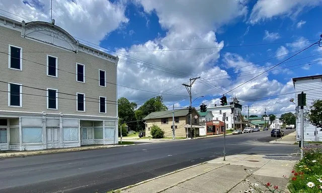 Looking northward along Main Street (NY 16) from just before the corner of Mill (left) and Church Streets (right) in the village center of Delevan, New York, as seen in July 2021.