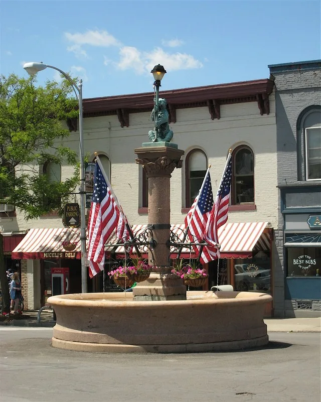 The Bronze Bear Fountain is the best-known symbol of Geneseo, New York. In this picture, the fountain is decorated with flags for Memorial Day.