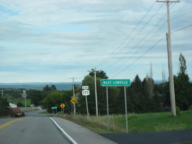 New York State Route 177 entering the hamlet of West Lowville, and approaching its terminus at New York State Route 12. The Adirondack Mountains form the landscape in the distance.