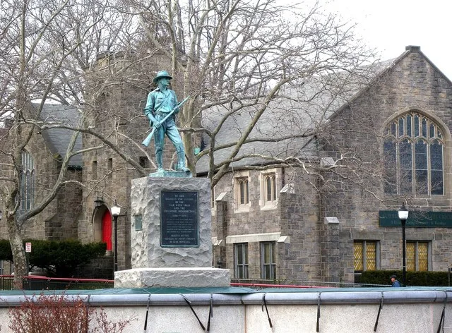 Looking northeast at statue and Community Church of the Circle in Mt Vernon on a cloudy afternoon
