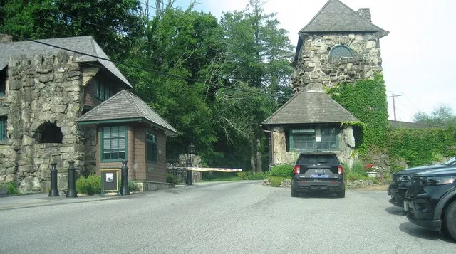 Photo of the main entrance to Tuxedo Park , New York , a gated village in Orange County . Photo taken from Tuxedo Road off New York State Route 17 looking west. Many Village of Tu...