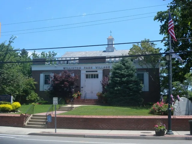 Looking east across Willis Avenue at Village Hall, on a sunny midday.