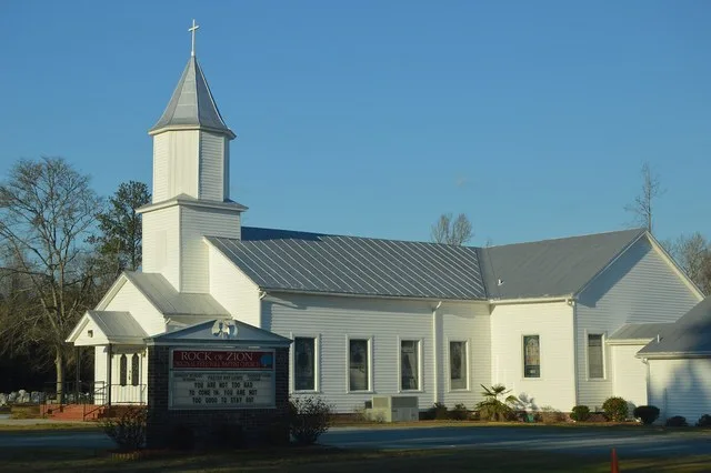 Southern side and front of Rock of Zion Original Free Will Baptist Church, located at 357 North Carolina Highway 306 in Grantsboro , North Carolina , United States .