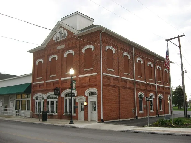 Front and western side of the village hall in Anna , Ohio , United States , located at 209 W. Main Street ( State Route 119 ). Built in 1880, it is listed on the National Register...
