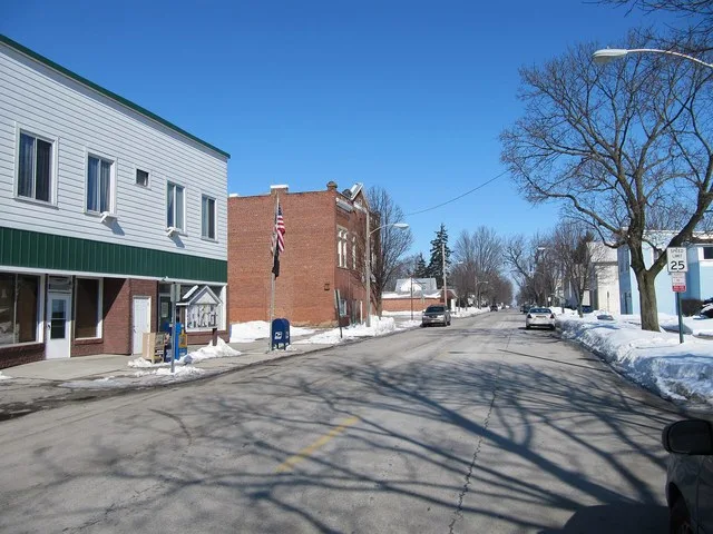 Photograph of the village of Bloomdale , Ohio en , taken at street level from Main Street, looking North toward the local office of the United States Postal Service en .