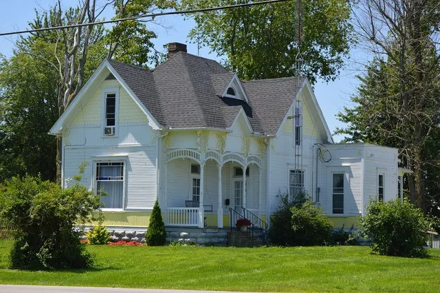 Front and northern side of the house located on the southwestern corner of the junction of River ( State Route 634 ) and Cedar Streets in Dupont , Ohio , United States . The appli...