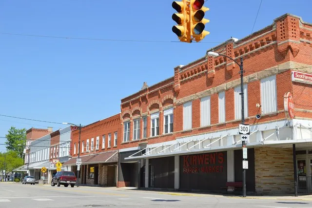 Buildings on the northern side of Madison Street ( State Route 600 ) looking west from Main Street ( State Route 300 ) in downtown Gibsonburg , Ohio , United States .