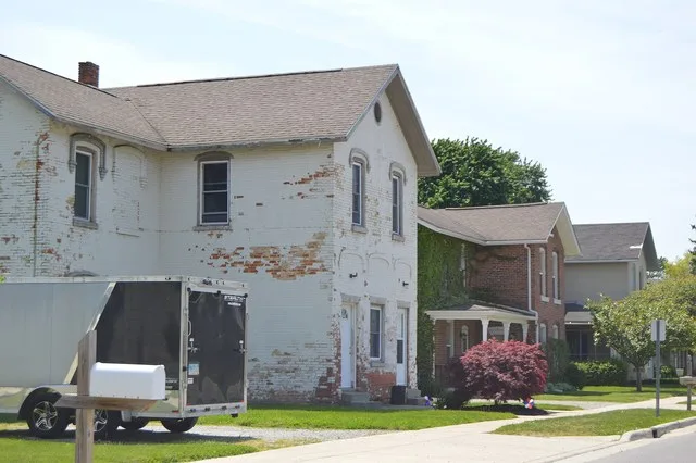 Houses on the southern side of Railroad Street, immediately west of the Maumee Street intersection, in Holland , Ohio , United States .