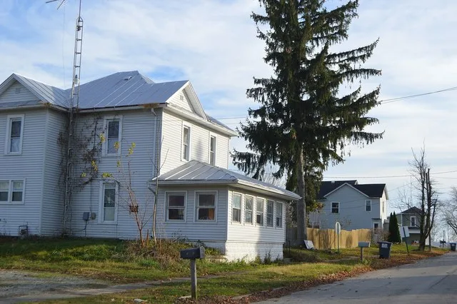 Houses on the eastern side of Elm Street at the Pease Street intersection in Hollansburg , Ohio , United States .