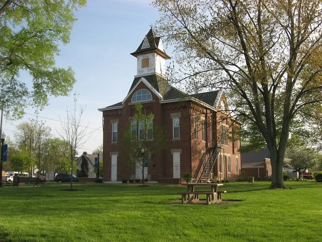 Front and northern side of the Monroe Township Hall-Opera House , located at 1 S. Main Street in downtown Johnstown , Ohio , United States . Built in 1884, it is listed on the Nat...