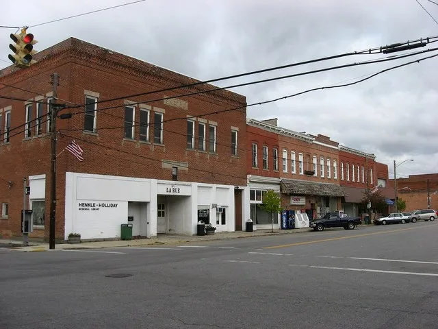 Business block in downtown LaRue , Ohio , United States , along the western side of the 100 block of N. High Street ( State Route 37 ). Marker at top of leftmost building (current...