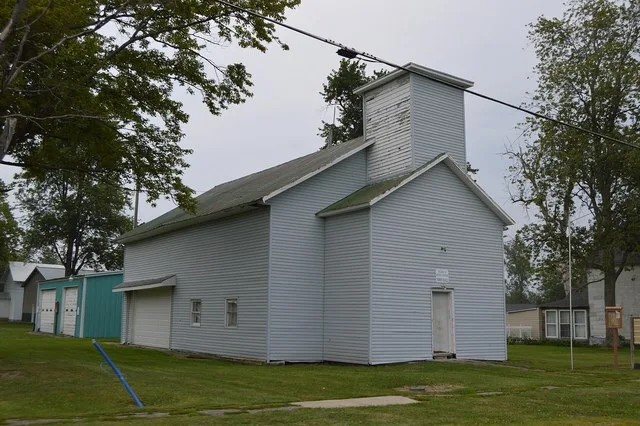 Front and western side of the Milton Center village hall, located at the junction of Church and Defiance Streets in Milton Center , Ohio , United States .