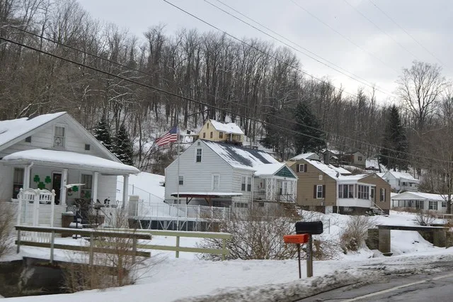 Houses on the southern side of New Alexandria Road ( State Route 151 ) in New Alexandria , Ohio , United States .
