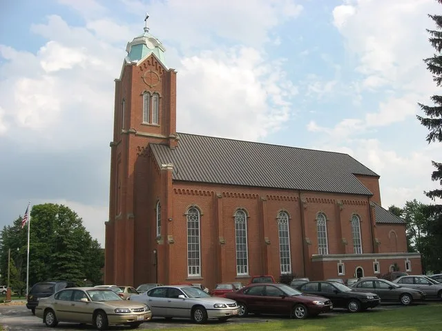 Northern side of All Saints Catholic Church (formerly St. Boniface's Catholic Church), located along N. Perry Street ( State Route 587 ) in New Riegel , Ohio , United States . Bui...