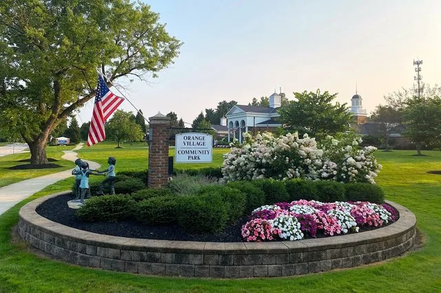 Entrance to Orange Village Community Park with Orange Village Hall in the background. August 2025.