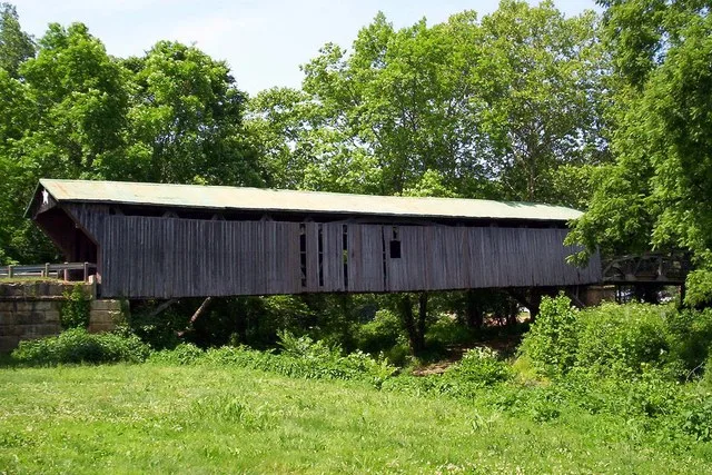 Side of the Otway Covered Bridge , which spans Scioto Brush Creek in Brush Creek Township , Scioto County , Ohio , United States . Built in 1874, the bridge is listed on the Natio...