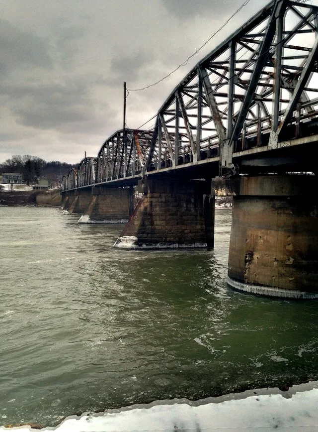Looking northward along the upstream side of the Muskingum River bridge between Philo and Duncan Falls in Muskingum County , Ohio , United States . It was built in 1953.