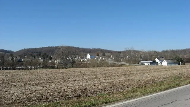 Looking westward across the Muskingum River toward Stockport , Ohio , United States . Toward the right side is the Stockport Bridge, which carries State Route 266 across the river...