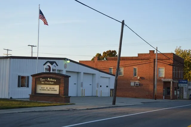 Two community buildings on the western side of Main Street ( State Route 39 ) at the Hilborn Avenue intersection in Tiro , Ohio , United States . The fire station sits in the fore...