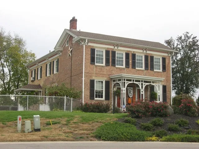 Front and western side of the Peter Schrock Jr. Farmhouse , located at 814 Carriage Lane in Trenton , Ohio , United States . Built in 1865, it is listed on the National Register o...