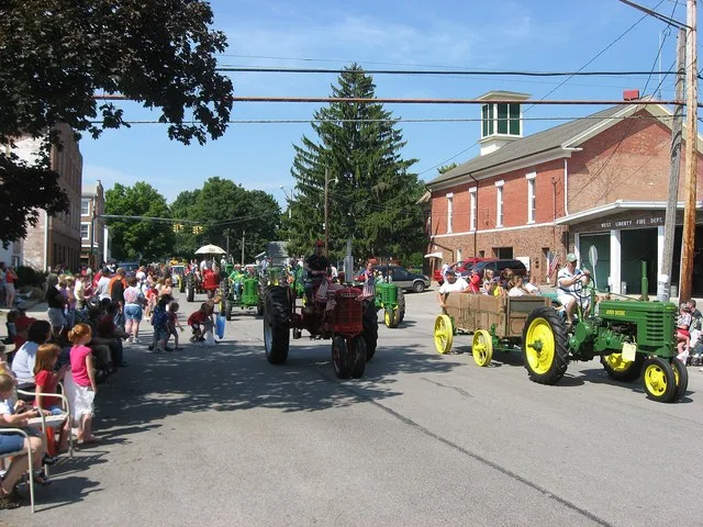 Annual Labor Day antique tractor parade in West Liberty , Ohio , United States . Photograph taken looking westward in the 100 block of E. Columbus Street, with the fire department...