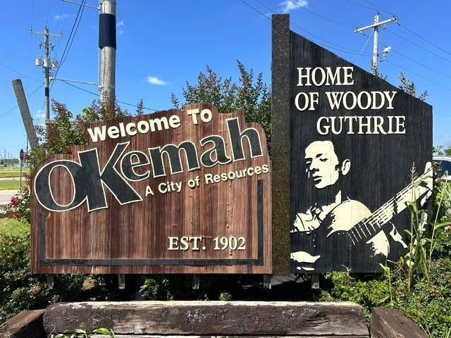Okemah welcome sign in June of 2026, referencing Woody Guthrie