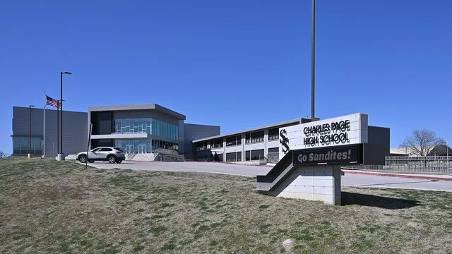 The sign for Charles Page High School with the school building behind it. Page H.S. is part of Sand Springs Public Schools, 500 North Adams Road, Sand Springs, Oklahoma 74063.