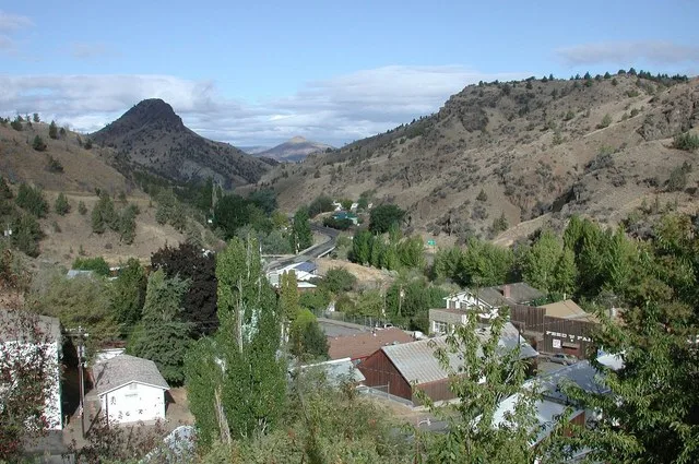 View of downtown Mitchell, Oregon, from Rosenbaum Street looking northwest. Rosenbaum Street is on the heights above Main Street, which crosses Bridge Creek (hidden by trees) and...
