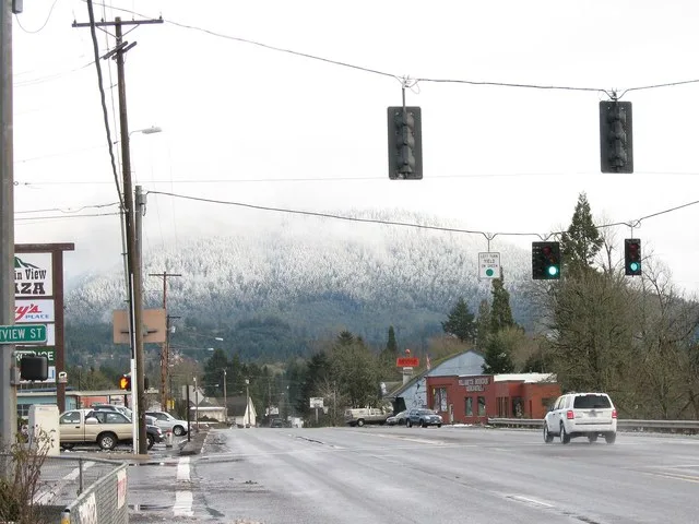 Highway 58 in Oakridge, Oregon, a city in Lane County, with snowy Cascade Range foothills in the background