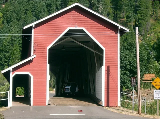Office Bridge seen from the south end with an SUV for scale; the pedestrian walkway is clearly visible.
