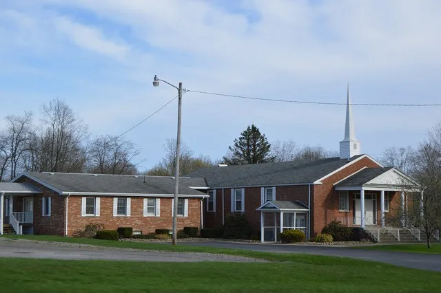 Northern side and front of the Calvary Orthodox Presbyterian Church , located at 443 N. Main Street ( Pennsylvania Route 8 ) in northern Harrisville , Pennsylvania , United States...