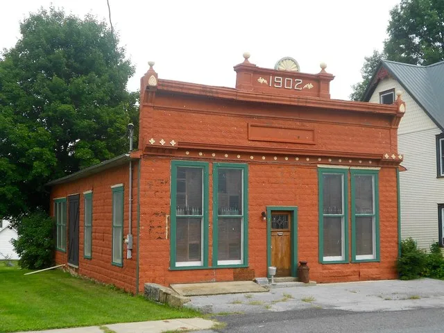 A municipal building in the borough of Howard, Pennsylvania with a 1902 datestone. Double doors on the left side suggest that this was used for storage or maybe as a stable. Acros...