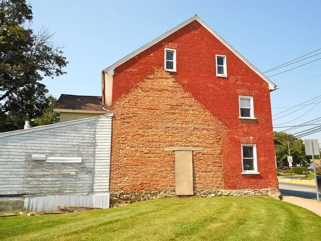 John Casper Stoever Log House House has been moved about 40 ft south and turned 90 degrees. The lot is for 200 West Main, the building next door is 204 W. Main. The "shadow matche...