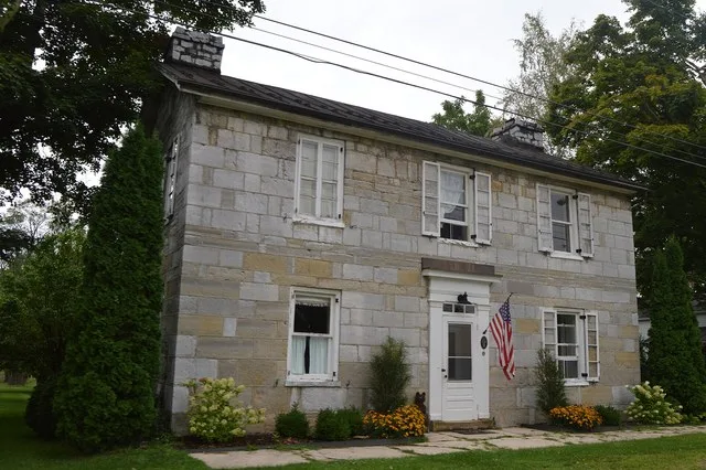 A stone house on the western side of Main Road ( Pennsylvania Route 326 ) in central Rainsburg , Pennsylvania , United States .