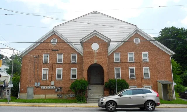 Big old funny apartment building near the center of Yoe, York County, Pennsylvania. A church and the fire station are across the street