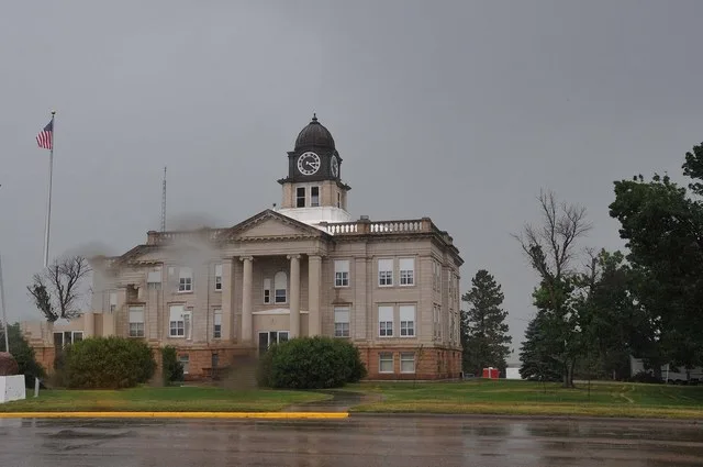 COURTHOUSE WAS ERECTED IN 1911 WITH CLASSICAL REVIVAL ELEMENTS. ITS ARCHITECT WAS W. M. RICH.