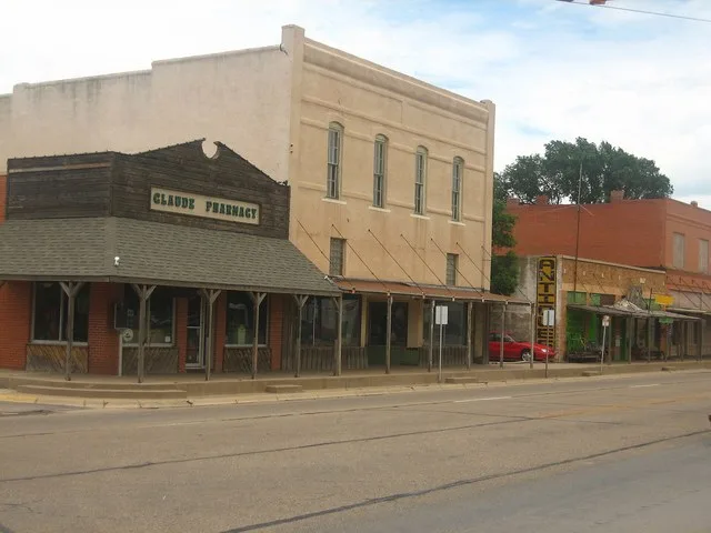 North side of 1st Street ( U.S. Route 287 ), Claude, Texas . At left, 101 N. Trice, the old Claude Pharmacy, Antique Soda Fountain & Flower Shop building, which later collapsed in...