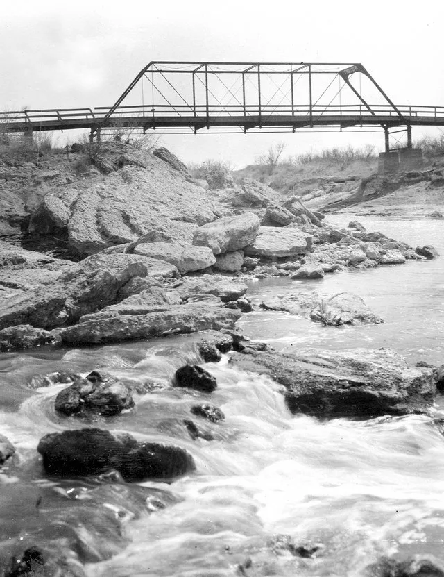 Bridge across Pecos River near Grandfalls, Texas outcrop of Jurassic Sediments in river. Ward County, Texas. 1910.