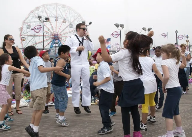 NEW YORK (May 26, 2011) Musician 3rd Class Tommy Stanley, from Kirbyville, Texas, assigned to the Navy Band Northeast Rhode Island Sound group, sings with children on the Coney Is...