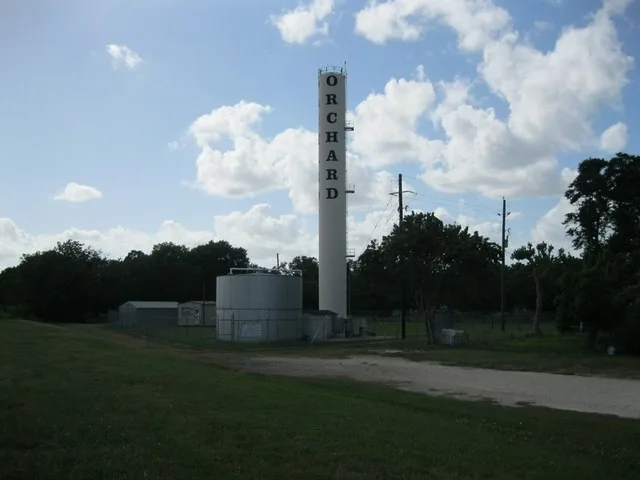 Photo shows the distinctive water tower located west of Missouri and Galveston Streets in Orchard, Texas. View is to the northwest.