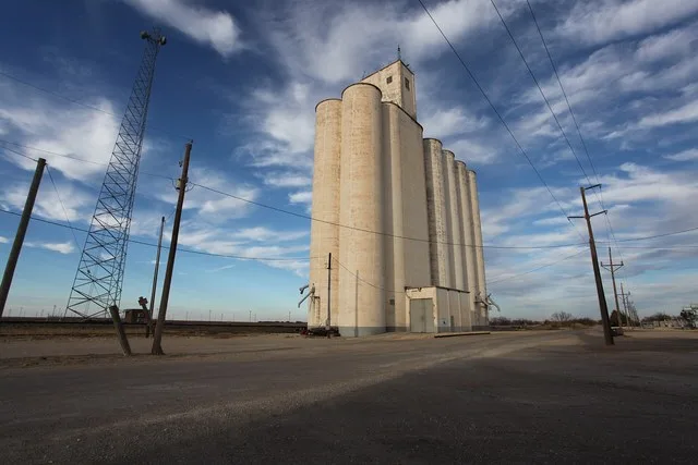 Plowboy grain elevator beside the tracks in Roscoe, Texas .