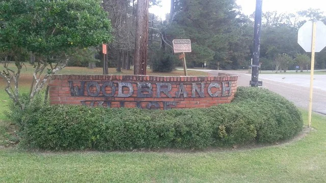 Welcome sign at the entrance to Woodbranch Village, Texas.
