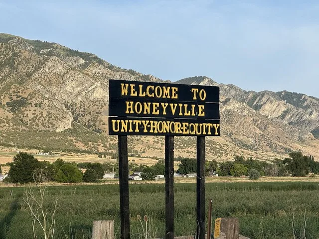 A welcome sign for Honeyville City, Utah heading eastbound on 6900 N (SR-240).