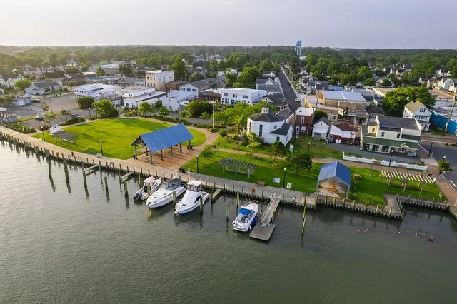 An aerial photograph of west/bayside Chincoteague Island at sunrise, with docked boats and a town park.