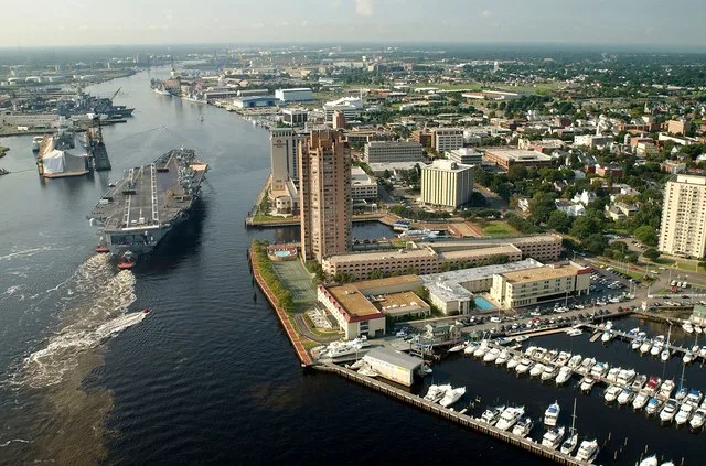 Portsmouth, Va. (Aug. 20, 2003) -- Tug boats guide USS Harry S. Truman (CVN 75) up the Elizabeth River, past Portsmouth landmarks, to the Norfolk Naval Shipyard to begin a Planned...