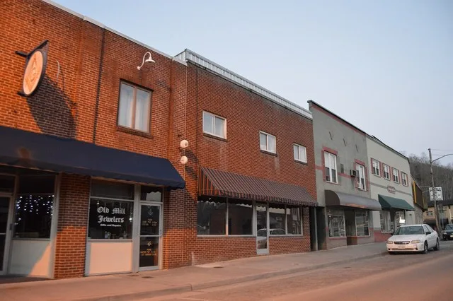 Buildings on the northern side of Main Street, just west of the Clintwood Highway intersection, in central Pound , Virginia , United States . Note the Masonic and jeweller's signs...