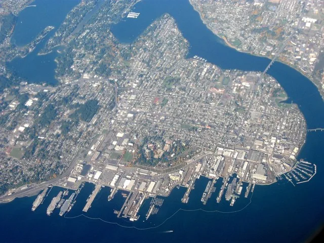 Aerial view of Bremerton, Washington, surrounded on three sides by water, out over Olympic Peninsula, facing northwest.