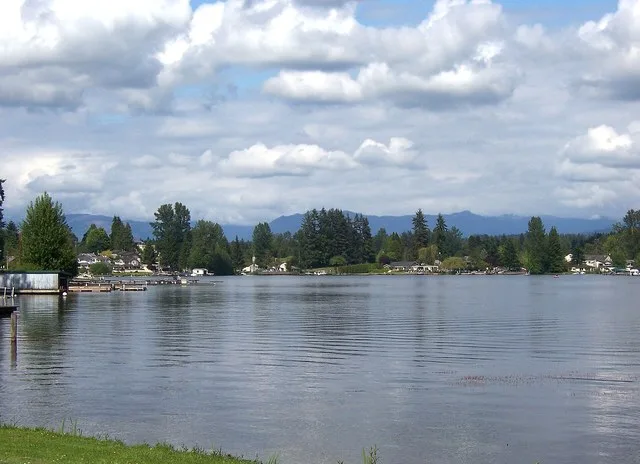 Looking towards the northeastern shores of Lake Stevens in Lake Stevens, Washington, USA, as seen from N Lakeshore Drive. The Cascade Mountains can be seen in the background.
