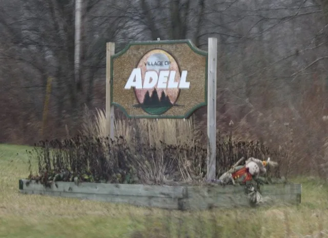 The city welcome sign for w:Adell, Wisconsin .