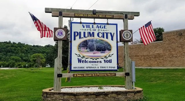 Sign welcoming visitors to Plum City, Wisconsin.